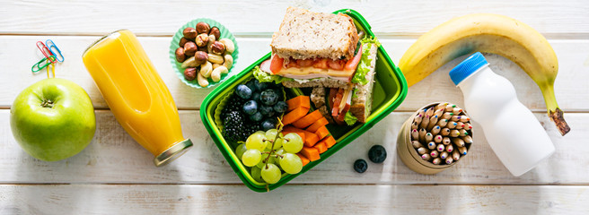 Back to school concept - lunch box with juice, apple and banana, copy space