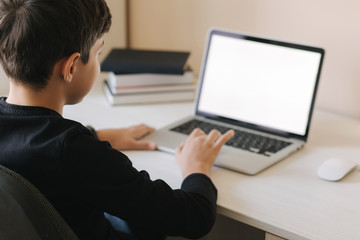 Teenage boy studing on paltip at home. Young boy play online games at home. Study in quarantine. Happy schoolboy during qurantine