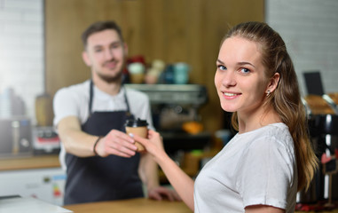 Young blonde girl buys coffee in a coffee shop. Small business concept