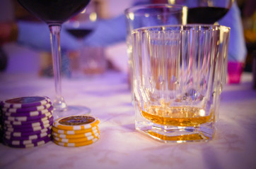 Poker chips with a glas of whiskey and wine