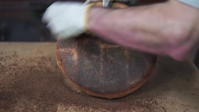 Freshly baked bread comes out of the bread oven.