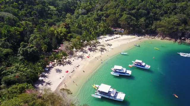 Aerial bird's eye view of boats docked in tropical beach - sapphire waters, Playa Mita, Riviera Nayarit, Mexico