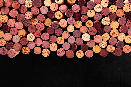 Wine corks background, a design template for a restaurant menu or winery brochure, shot from the top with a place for text, on a black background