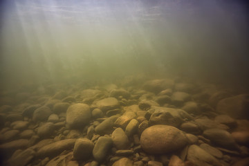 stones at the bottom underwater landscape, abstract blurred under water background