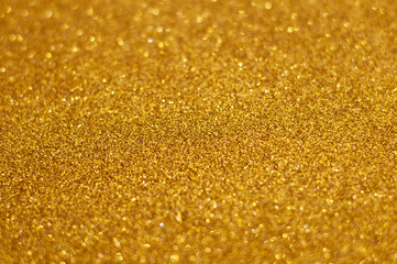 Gold glitter texture abstract background. Shiny glowing colors. Concept of wealth, love, glamour or passion.