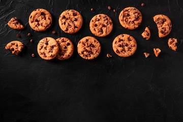 Chocolate chip cookies on a black background, shot from the top with a place for text