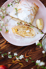 Healthy Home made sweet Apple strudel with raisins and cinnamon on wooden background with blooming fruit branches