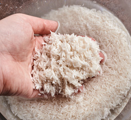 white basmati rice in water in a glass bowl on a brown background