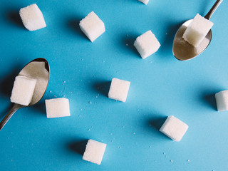 Sugar cube on a blue background shot on macro. Teaspoon sugar