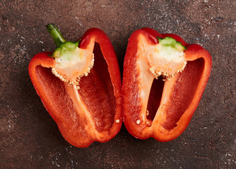 fresh red pepper cut in half on a brown background