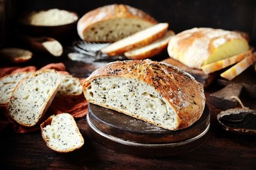 Homemade bread assortment: corn, with sesame seeds and chia seeds on a dark wooden background....