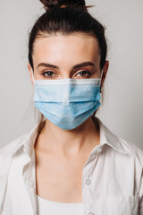 Portrait young woman wearing hygienic mask to prevent infection isolated on white background.