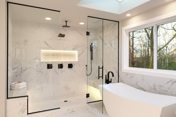 Detailes of the larhe walk in shower with white marble and mosaic, light. Three handles, shower head in dark brass.and free standing modern tub. - obrazy, fototapety, plakaty