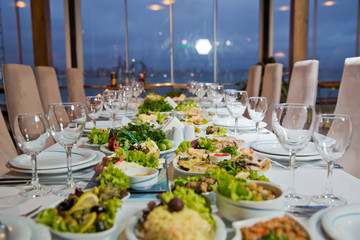Salads and gums . Set of a dish with spoon, fork and knife on white table.Table setting on white table .