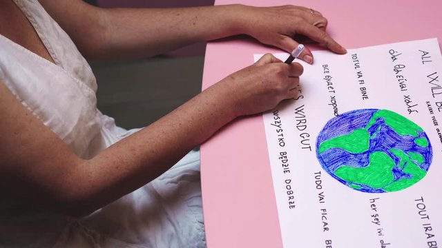 Woman writes all will be ok in many languages as hope against COVID-19