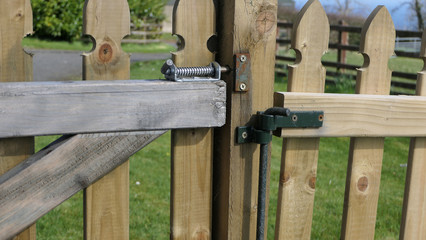 Wooden fence and gate for children on garden lawn