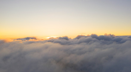 Aerial view clouds. View from drone. Aerial top view cloudscape. Texture of clouds. View from above. Sunrise or sunset over clouds. Panorama clouds