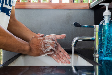 Man is washing his hands in a sink sanitizing the colona virus for sanitation and reducing the spread of COVID-19 spreading throughout the world, Hygiene ,Sanitation concept.