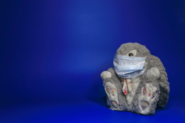 masked toy protecting against infection, coronavirus, on blue background