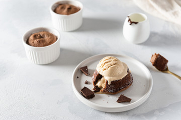 Warm Chocolate Lava Cake with Bite Taken Out of Molten Center and scoop of vanilla ice cream on white background. Restaurant, bakery, confectionery menu, recipe