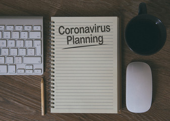 Desktop flatlay of a notebook with a business planning for Coronavirus and the future by thinking ahead and forward thinking with copy space