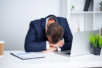Tired employee working at desk at company office