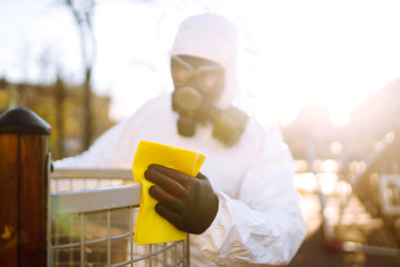 Hand of Man in protective suit washing and disinfection the playground, to preventing the spread of the epidemic of coronavirus, pandemic in quarantine city. Covid-19.