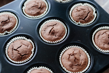 Chocolate cupcakes. Homemade chocolate muffins. The process of making homemade chocolate cupcakes with whipped cream and decorated with chocolate and raspberry pieces.