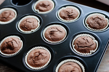 Chocolate cupcakes. Homemade chocolate muffins. The process of making homemade chocolate cupcakes with whipped cream and decorated with chocolate and raspberry pieces.