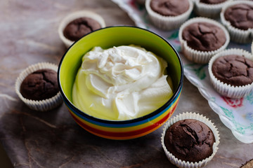 Chocolate cupcakes. Homemade chocolate muffins. The process of making homemade chocolate cupcakes with whipped cream and decorated with chocolate and raspberry pieces.