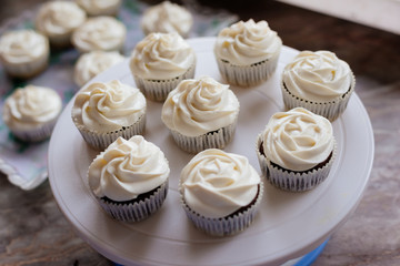 Chocolate cupcakes. Homemade chocolate muffins. The process of making homemade chocolate cupcakes with whipped cream and decorated with chocolate and raspberry pieces.