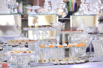 Dessert table for a party. Ombre cake, cupcakes, sweetness and flowers