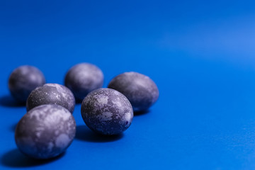 Eggs with marble stone effect painted with natural dye carcade flower on blue sparkling background