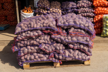 Potatoes in bags at the market. A lot of potatoes in the vegetable store. Selling vegetables from the farm.