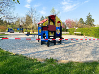 Children's playground in the park is closed and wrapped in alarm caution tape for global coronavirus quarantine. No children on playgrounds in Europe. Prevention of coronavirus COVID-19.
