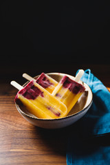 Fruit homemade popsicles made are from fresh mango, blackcurrant and coconut milk. Healthy vegan summer dessert.