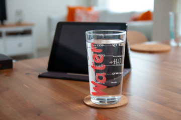 young beautiful lady drinking water in clean clear glass standing on table healthy