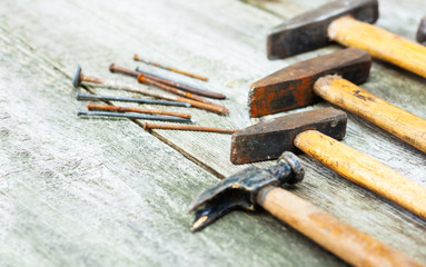 Set of vintage hand construction and carpentry tools hammers on a old wooden background, retro...