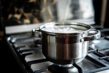 Stainless steel cooking pot on gas stove in kitchen. 