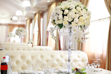 Wedding. Banquet. The chairs and round table for guests, served with cutlery, flowers and crockery...