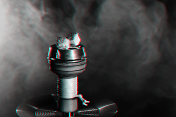 charcoals in a hookah bowl with smoke on a dark background