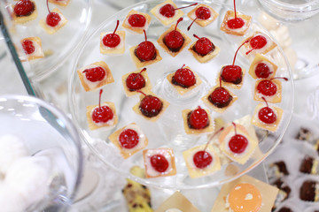 Dessert table for a party. Ombre cake, cupcakes, sweetness and flowers