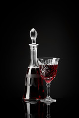 Carafe and crystal glass of wine on a black background in the studio
