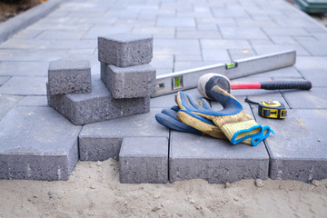 Paving stones pathway paving background. Installing tools on foreground