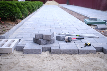 Paving stones pathway paving background. Installing tools on foreground