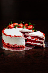 Red velvet cake on a dark background. Red velvet cake in white butter cream decorated with...