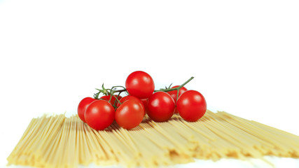 spaghetti and cherry tomatoes: typical ingredients of Italian cuisine in a minimalist composition with a totally white background
