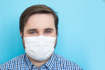 Man in protective mask against infectious diseases isolated on blue background, health care concept. Coronavirus quarantine.