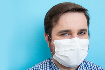 Man in a protective mask against coronavirus isolated on blue. Coronavirus man mask, copyspace, copyplace, space for text. Coronavirus, illness, infection, quarantine, medical mask