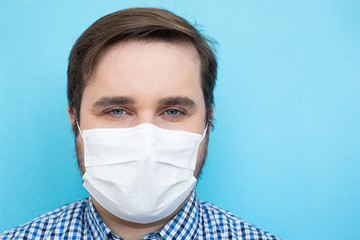 Man in protective face mask isolated on blue background, copyspace, copyplace, space for text. Coronavirus, illness, infection, quarantine, medical mask